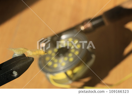 Tying a yellow fly Tying a yellow fly 109166323