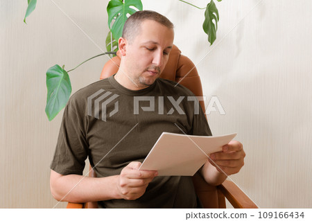Portrait of a depressed young man sitting at home. Post-traumatic stress disorder concept 109166434