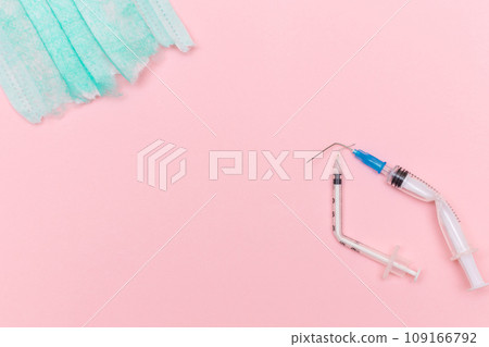 Broken Medical Syringe and Torn Medical Face Mask on the Pink Background Broken Medical Syringe and Torn Medical Face Mask on the Pink Background 109166792