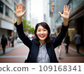 Smiling Japanese woman raising her hands in joy 109168341
