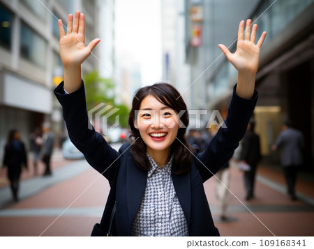 Smiling Japanese woman raising her hands in joy 109168341