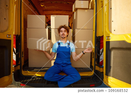 Courier meditating to keep calm holding parcel box in hand 109168532