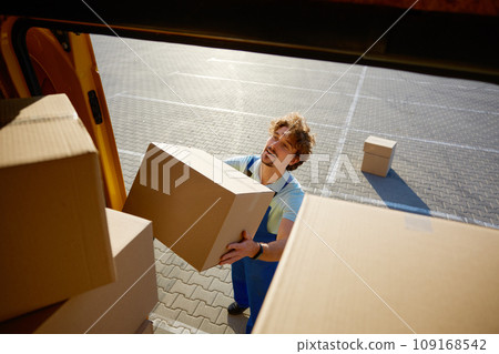Young warehouse worker holding clipboard box unloading delivery truck van 109168542