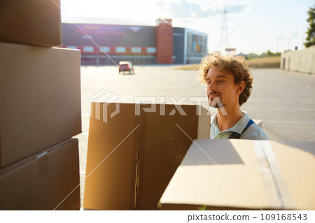 Young warehouse worker holding clipboard box unloading delivery truck 109168543