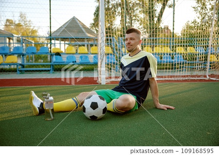 Young sportive man relaxing after soccer game training 109168595