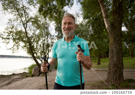 Portrait of senior man enjoying beautiful park scenery during hike in summer 109168739