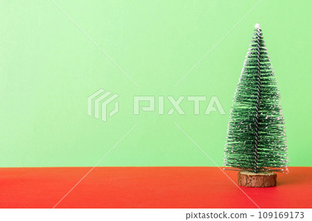 One small Christmas tree on colored background. new year decoration with copy space One small Christmas tree on colored background. new year decoration with copy space 109169173