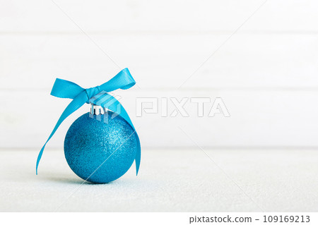 Christmas ball on colored background. decoration bauble with ribbon bow with copy space Christmas ball on colored background. decoration bauble with ribbon bow with copy space 109169213