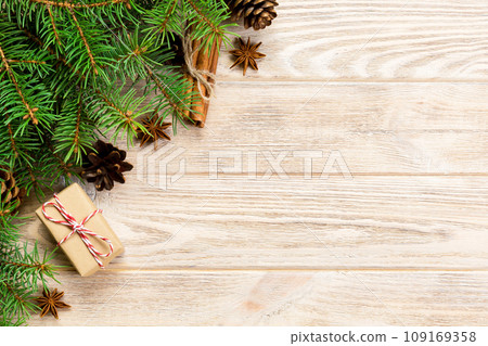 gift boxwith cinnamon sticks, anise stars, pine cones and pine branches on wooden table. Top view. Christmas gifts in woodan style 109169358