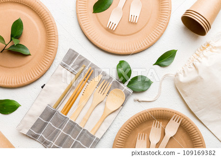set of empty reusable disposable eco-friendly plates, cups, utensils on light white colored table background. top view. Biodegradable craft dishes. Recycling concept. Close-up set of empty reusable disposable eco-friendly plates, cups, utensils on light white colored table background. top view. Biodegradable craft dishes. Recycling concept. Close-up 109169382