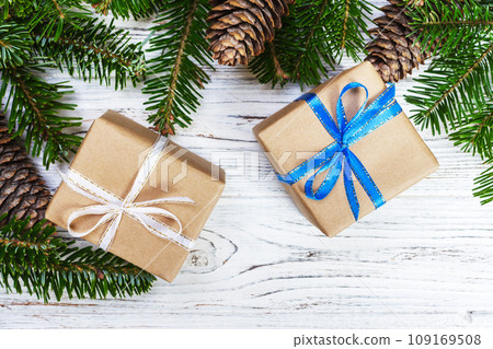 Christmas gift box on the white wooden table background,spruce branch,pine cones,frame,top view,space for text Christmas gift box on the white wooden table background,spruce branch,pine cones,frame,top view,space for text 109169508