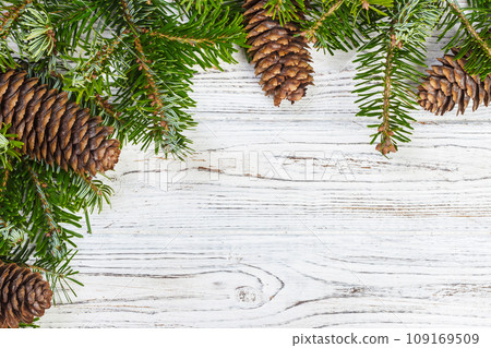Christmas background. Fir tree branch pine cones at wooden table. Flat lay, space for text 109169509