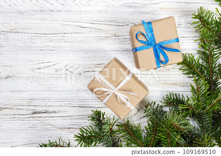 Wrapped Christmas gifts on dark rustic wooden table with pine cones and fir branches. With copy space for your text 109169510