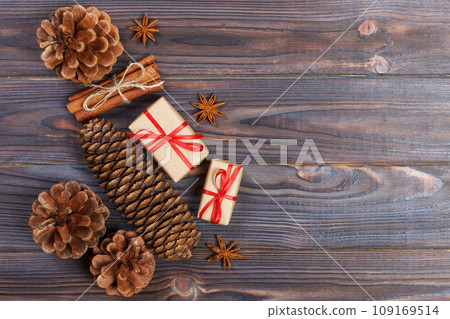 top view of christams gift with pine cones and cinnamon sticks 109169514
