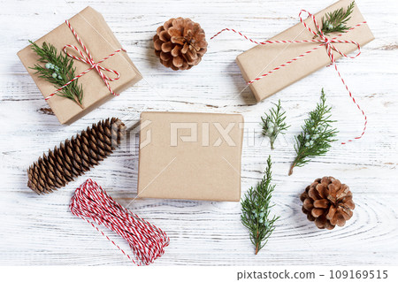 Christmas background with hand crafted gifts, presents on rustic wooden table. Christmas or New year DIY packing. Holiday decor concept. Overhead, flat lay, top view 109169515
