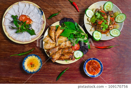 Traditional fried vietnamese spring rolls with pork, rice paper with sauces, meat slices and beef stew Traditional fried vietnamese spring rolls with pork, rice paper with sauces, meat slices and beef stew 109170756
