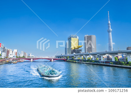 Water bus running along the Sumida River and surrounding urban scenery [Tokyo, Taito Ward - Sumida Ward] 109171256