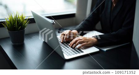 Close up Asian business woman using laptop to calculate tax and financial data of business at office 109171352