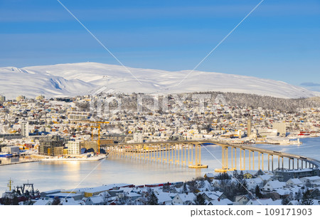 Snowy roofs, embankment near the port and fishing ships, Sunny winter day. Snowy roofs, embankment near the port and fishing ships, Sunny winter day. 109171903