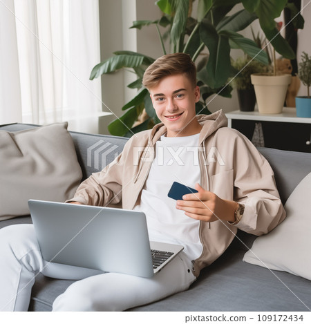 Teenage boy shops online via laptop, living room Teenage boy shops online via laptop, living room 109172434