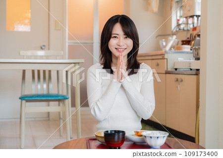 A woman living alone eating dinner in a simple house 109173400