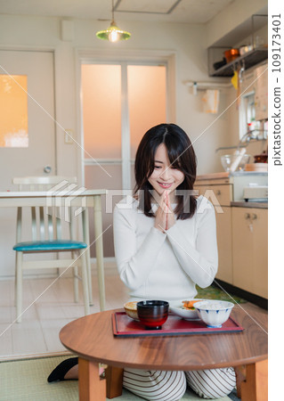 A woman living alone eating dinner in a simple house 109173401