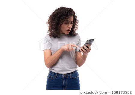 bright young european slender brunette woman with curly hair styling dressed in a gray t-shirt 109173598