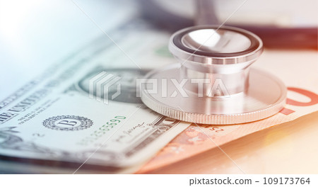 Medical stethoscope close-up on top of Dollar banknotes side view 109173764