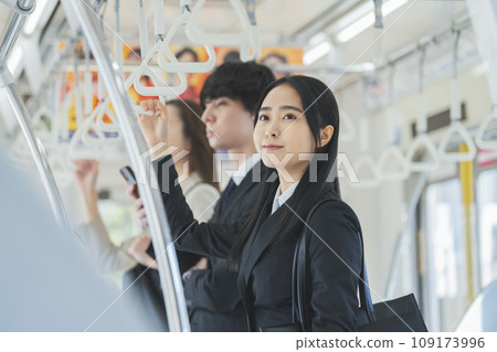 A young business woman commuting by train. Photography provided by Keio Electric Railway Co., Ltd. 109173996