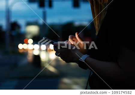 Woman using smartphone at evening street 109174582