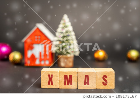 Wooden blocks with the word Xmas, miniature house and a Christmas tree. New Year or Xmas winter holiday. Decoration, celebration. The concept of the beginning of the new year. Snow, snowfall 109175167