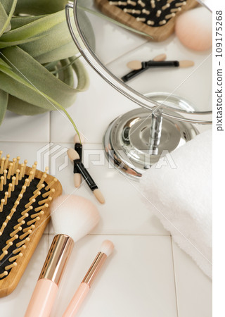 Stylish makeup tools and clean towels arranged on white tiles 109175268
