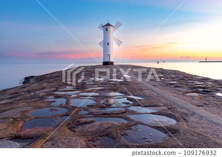 Swinoujscie. The famous stone lighthouse in the form of a windmill at dawn. Swinoujscie. The famous stone lighthouse in the form of a windmill at dawn. 109176932