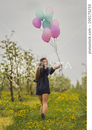 girl with balloons in a young garden 109178250