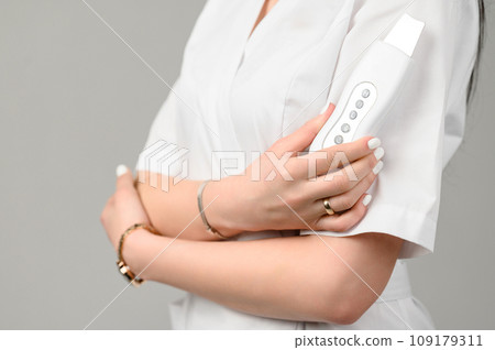 a young cosmetologist girl holds in her hands an ultrasonic scrubber. a young cosmetologist girl holds in her hands an ultrasonic scrubber. 109179311