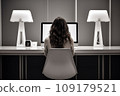young woman working from home in front of a computer monitor. The apartment is minimalistic 109179521