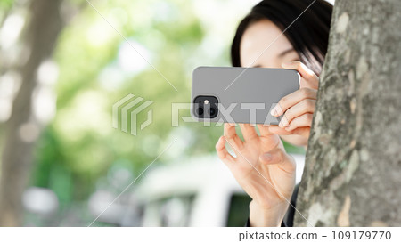 一名女子用智慧型手機偷偷拍照 一名女子用智慧型手機偷偷拍照 109179770