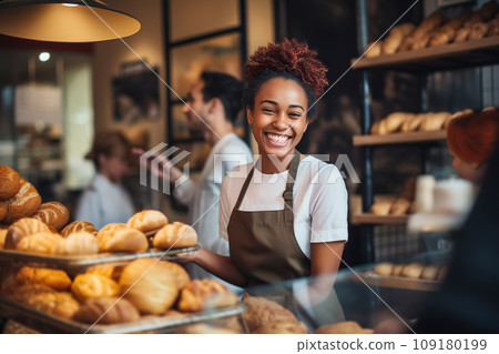 Attractive female seller puts fresh pastries on display and sells them to customers Attractive female seller puts fresh pastries on display and sells them to customers 109180199