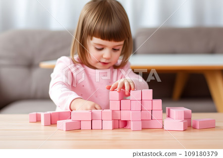 Cute little girl playing with pink wooden blocks. Sustainable eco friendly toys Cute little girl playing with pink wooden blocks. Sustainable eco friendly toys 109180379