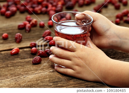 Boy s hand holding glass of rosehip tea Boy s hand holding glass of rosehip tea 109180485