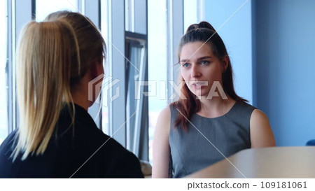Young women talk and smile during break in company lounge 109181061