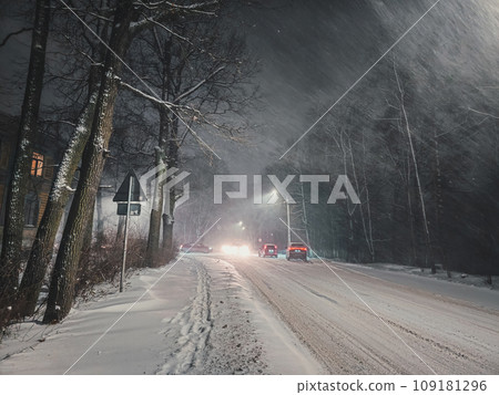 Night snowfall on a city street. A strong blizzard on the highwa Night snowfall on a city street. A strong blizzard on the highwa 109181296