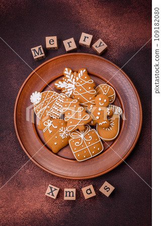 Beautiful delicious sweet winter Christmas gingerbread cookies on a bronze textured background Beautiful delicious sweet winter Christmas gingerbread cookies on a bronze textured background 109182080