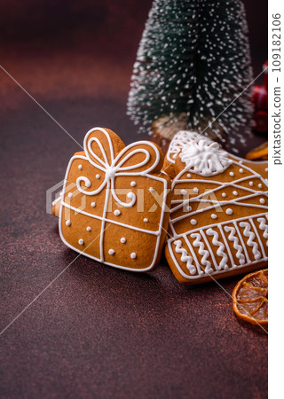 Beautiful delicious sweet winter Christmas gingerbread cookies on a bronze textured background Beautiful delicious sweet winter Christmas gingerbread cookies on a bronze textured background 109182106