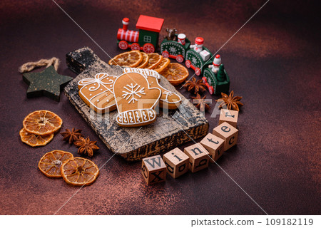 Beautiful delicious sweet winter Christmas gingerbread cookies on a bronze textured background Beautiful delicious sweet winter Christmas gingerbread cookies on a bronze textured background 109182119
