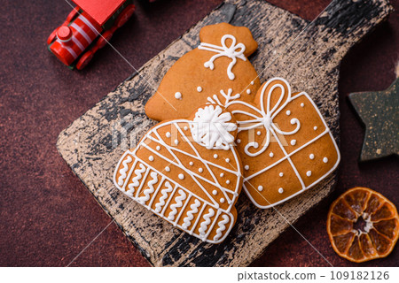 Beautiful delicious sweet winter Christmas gingerbread cookies on a bronze textured background Beautiful delicious sweet winter Christmas gingerbread cookies on a bronze textured background 109182126