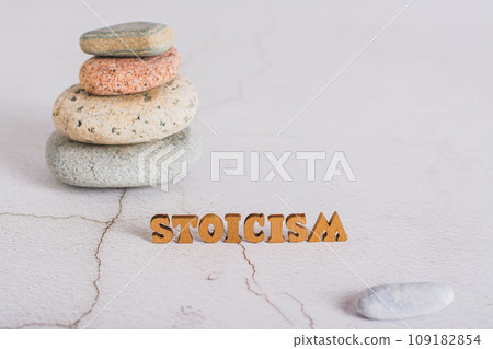 Concept of stoicism wooden letters on the background of a pyramid of stones on the table 109182854