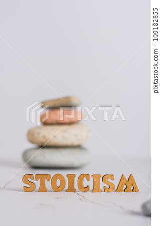 Concept stoicism word made from letters and pyramid of stones on gray background vertical view Concept stoicism word made from letters and pyramid of stones on gray background vertical view 109182855