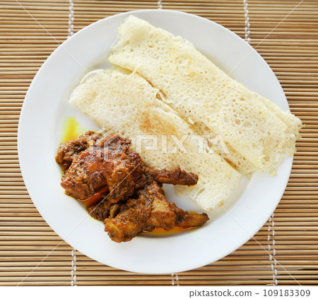 Chita ruti a Bengali cuisine with hot chicken curry Chita ruti a Bengali cuisine with hot chicken curry 109183309