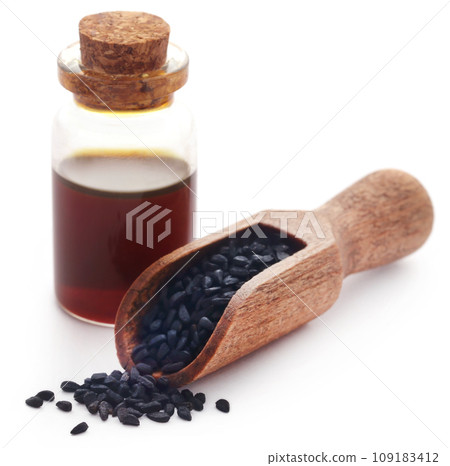 Nigella seeds and essential oil in a glass bottle Nigella seeds and essential oil in a glass bottle 109183412